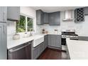 Modern kitchen with gray cabinetry, stainless steel appliances, white countertops, and a farmhouse sink at 3331 Eastwood Dr, Charlotte, NC 28205