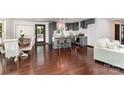 Open concept kitchen and dining area with hardwood floors, gray cabinets, and an island with barstools at 3331 Eastwood Dr, Charlotte, NC 28205