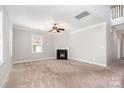 Open living room with a fireplace, neutral walls, carpet flooring, and a ceiling fan at 4504 Sages Ave, Indian Trail, NC 28079