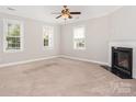 Bright living room with a fireplace, neutral walls, carpet flooring, and abundant natural light at 4504 Sages Ave, Indian Trail, NC 28079