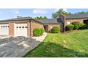 Charming single-story brick home featuring a well-maintained lawn, landscaping, and two-car garage at 608 Camrose Ne Cir, Concord, NC 28025