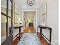 Elegant foyer with hardwood floors, rug, decorative tables, and artwork at 6128 Fletcher Cir, Charlotte, NC 28226