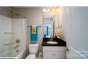 Bright bathroom with tub and shower combo, granite counters, and modern hardware at 107 Asmodean Ln, Troutman, NC 28166