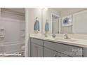 Bright bathroom boasting double sinks, gray cabinets, and a convenient shower-tub at 115 Asmodean Ln, Troutman, NC 28166