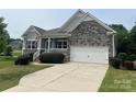 Charming home featuring stone accents, a two-car garage, and a well-maintained front lawn at 120 Autumn Mist Rd, Statesville, NC 28677