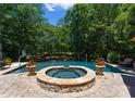Beautiful swimming pool and spa surrounded by lush greenery and stone pavers at 13837 Grand Palisades Pkwy, Charlotte, NC 28278