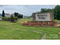 Beautiful community entrance featuring a stone sign, landscaping, and green space at 144 Parker Claire Ln, Kings Mountain, NC 28086