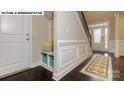 Inviting foyer with a built-in bench and storage, complemented by dark hardwood floors and white trim at 146 Asmodean Ln, Troutman, NC 28166