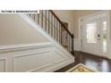 Bright foyer features dark hardwood flooring, white wainscoting, and an elegant front door with sidelights at 146 Asmodean Ln, Troutman, NC 28166