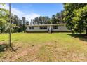 Cozy single-story home with a green lawn and bordered by lush trees at 151 Lillyfield Dr, Rockwell, NC 28138