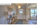 Bright entryway with hardwood floors and decorative table and lamp at 160 Asmodean Ln, Troutman, NC 28166
