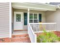 Close-up of the front porch featuring brick steps and a white railing at 2023 E Park Dr, Lancaster, SC 29720