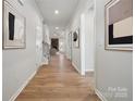 Inviting hallway with hardwood floors and modern artwork on the walls at 2045 Mantle Ridge Dr, Indian Trail, NC 28079