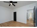 Bright, minimalist bedroom boasts wood-look flooring, modern ceiling fan, and black door at 315 W Hoke W St, Landis, NC 28088