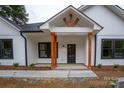 Inviting front porch with stylish wood columns, black door, and clean concrete walkway at 315 W Hoke W St, Landis, NC 28088