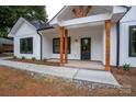 Inviting front porch with stylish wood columns, black door, and clean concrete walkway at 315 W Hoke W St, Landis, NC 28088