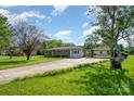 Traditional home with brick accents and a long driveway leading to a detached carport, surrounded by lush greenery at 319 Glenhaven Dr, Charlotte, NC 28214