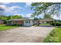 Charming single-story home with a brick facade, awning accents, and a spacious carport at 319 Glenhaven Dr, Charlotte, NC 28214