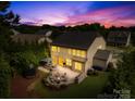 Inviting backyard at dusk with firepit, patio, outdoor seating and lush landscaping, perfect for entertaining at 3918 Halcyon Dr, Huntersville, NC 28078