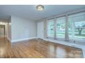 Inviting living room with hardwood floors, large windows, and neutral paint at 3951 Whitehall Dr, Charlotte, NC 28208