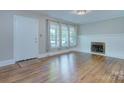 Bright living room featuring refinished hardwood floors and a cozy fireplace at 3951 Whitehall Dr, Charlotte, NC 28208