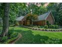 Charming brick home with manicured lawn, lush landscaping, and inviting curb appeal on a sunny day at 5208 Black Oak Ln, Waxhaw, NC 28173