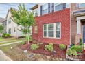 Up close front brick facade, lush landscaping, and healthy lawn at 5391 Orchid Bloom Dr, Fort Mill, SC 29707