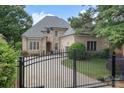 Beautiful brick and stone home featuring a two car garage and a well manicured lawn with a gate at 6132 Sharon Rd, Charlotte, NC 28210