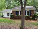 Charming home featuring a well-maintained lawn, a partial brick facade, and eye-catching blue shutters at 7212 Bradley Ct, Charlotte, NC 28227