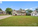 Green, grassy lawn surrounds single story home with wood beams and shutters at 107 Pressley St, Clover, SC 29710