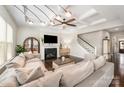 Cozy living room features a fireplace, ceiling fan, and staircase to the upper level at 1111 Thessallian Ln, Indian Trail, NC 28079