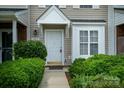 Close-up of an inviting entryway with lush green bushes and a well-lit walkway at 15042 Deshler Ct, Charlotte, NC 28273