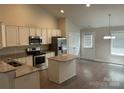 Well-lit kitchen boasts stainless steel appliances, ample white cabinetry, granite counters, and an island with bar seating at 1521 Park Ave, Salisbury, NC 28146