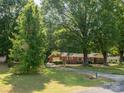 A brick home with a long driveway surrounded by mature trees and a green lawn at 160 Eagle Dr, Salisbury, NC 28144