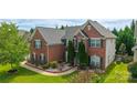 Two-story brick home featuring well-maintained landscaping, dark shutters, and a gray roof at 16012 Caranna Ct, Charlotte, NC 28277