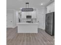 Bright open-concept kitchen featuring a white island and cabinets, stainless steel appliances, and a modern light fixture at 1933 St Mark St, Charlotte, NC 28216