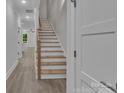 View of a staircase with wood treads and white risers, complemented by light-colored walls and wood-look floors at 1933 St Mark St, Charlotte, NC 28216
