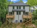 Rear exterior of a white two-story home featuring wood decks and many windows overlooking the backyard at 1935 St Mark St, Charlotte, NC 28216