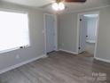 A bedroom showing neutral walls, a ceiling fan, new flooring, and a bright window at 209 Barber Rd, Gastonia, NC 28056