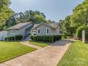 Inviting single-story home with a neatly paved driveway and professionally landscaped front yard at 214 Wilcrest Dr, Matthews, NC 28105