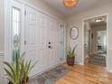 Bright foyer featuring decorative glass side panels, a hardwood floor, and neutral wall colors at 214 Wilcrest Dr, Matthews, NC 28105