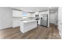 A kitchen boasts stainless steel appliances, wood flooring and white cabinets and countertops at 217 Basildon St # 1018, Lancaster, SC 29720