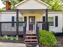 Close up of the covered front porch with wooden railings and a painted front door at 22 Walnut Nw Ave # 1, Concord, NC 28027