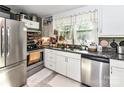 Functional kitchen featuring a stainless steel refrigerator, double sink, and ample counter space at 22 Walnut Nw Ave # 1, Concord, NC 28027