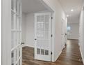 Bright hallway with hardwood floors, white trim, and glass-paned doors at 2605 Goose Fair Rd, Maiden, NC 28650