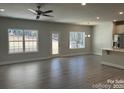 Open concept living room with hardwood floors, ceiling fan, lots of light, and view of stainless steel kitchen appliances at 2924 Noritake Trl # 67, Albemarle, NC 28001