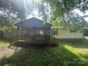 Exterior showcasing a welcoming porch framed by lush greenery and a canopy of trees at 3103 Blue Ridge Dr, Shelby, NC 28150