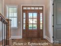 Beautiful wood front door with glass panels and sidelights, complemented by hardwood floors at 3439 Stags Leap Way, York, SC 29745