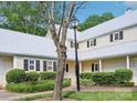 Charming home exterior with a light-colored facade, black shutters, metal roof, and beautiful landscaping at 3810 Selwyn Farms Ln # 3, Charlotte, NC 28209