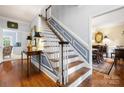 Inviting entryway with beautiful hardwood floors, staircase, and a glimpse into the dining room at 3909 Black Sycamore Dr, Charlotte, NC 28226